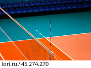 Professional volleyball court with net in sporty gym, row of chair. Sport backgrounds, volleyball courts in sport hall. Team game success, healthy sporty lifestyle concept. Copy ad text space poster. Стоковое фото, фотограф Aleksandr Golubev / Фотобанк Лори
