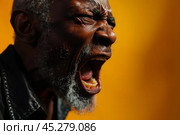 Expression of furious, enraged senior grey bearded afro man with grumpy grimace on his face, mouth opened in shout, ready to argue and swear, Angry black man yelling, screaming on yellow background. Стоковое AI-изображение, AI-художник Sergey Grishin / Фотобанк Лори
