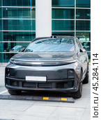Hybrid car LiXiang L7 parked in front of modern glass building. Редакционное фото, фотограф Константин Григорьев / Фотобанк Лори