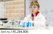 a student in a chemical laboratory conducts chemical sweats with chemical elements. Стоковое фото, фотограф Igor Skripachev / Фотобанк Лори