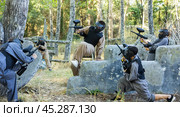 Paintball team rushing enemy positions on battleground. Стоковое фото, фотограф Яков Филимонов / Фотобанк Лори