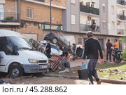 The aftermath of hurricane Dana in Valencia, Spain - Devastating aftermath of flooding in Valencia, cars piled up and debris scattered across streets. Стоковое фото, фотограф Данил Руденко / Фотобанк Лори