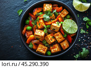Colorful fresh salad ingredients arranged in a bowl with lime and herbs on a dark surface. Стоковое AI-изображение, AI-художник Юлия Гапеенко / Фотобанк Лори