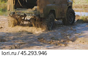 An off-road vehicle is plunging through a muddy puddle, creating a massive splash and showcasing its power and resilience. The car stops, steer driver walks up to it and opens the door. Slow motion. Стоковое видео, видеограф Воловодов Владимир / Фотобанк Лори