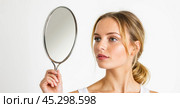 Joyful lady in front of mirror showcases beauty products. Her flawless skin and vibrant smile signify healthy living, representing elegance and well-being. Стоковое AI-изображение, AI-художник Павел Муравьев / Фотобанк Лори
