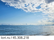 Голубая вода озера Иссык-Куль, Кыргызстан, Киргизия. Солнечные лучи пробиваются сквозь белые облака. Стоковое фото, фотограф Екатерина Якименко / Фотобанк Лори