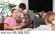 Curious underage girl engaged in IT training with help of teacher in computer courses. Стоковое видео, видеограф Яков Филимонов / Фотобанк Лори