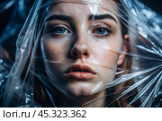 The girl is wrapped in cellophane or a bag. The girl is suffocating. Plastic pollution of the planet. Environmental hazard. Reducing the reuse of plastic. Recycling. The concept of garbage. Стоковое AI-изображение, AI-художник Photojuli / Фотобанк Лори