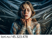The girl is wrapped in cellophane or a bag. The girl is suffocating. Plastic pollution of the planet. Environmental hazard. Reducing the reuse of plastic. Recycling. The concept of garbage. Стоковое AI-изображение, AI-художник Photojuli / Фотобанк Лори