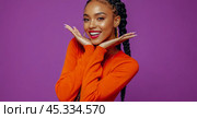 Cheerful Young African American Woman with Long Braids Wearing Vibrant Orange Top Posing for Advertisement, Exuding Warmth and Enjoyment. Стоковое AI-изображение, AI-художник Павел Муравьев / Фотобанк Лори