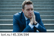Corporate professional in despair sitting on staircase, encapsulating themes of financial collapse, career setbacks, burnout, and overwhelming stress. Стоковое AI-изображение, AI-художник Павел Муравьев / Фотобанк Лори