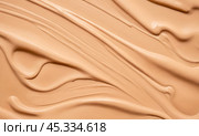 Beige foundation makeup texture swiped on surface, creamy cosmetic product wave pattern, closeup view of skin tone beauty enhancer for smooth complexion. Стоковое фото, фотограф Павел Муравьев / Фотобанк Лори