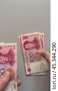 Vertical video of men's hands counting paper money Chinese yuan. 100 yuan bills fall on a light table. Flat lay, close-up, top view, copy space, mock up. Стоковое видео, видеограф Виктория Катьянова / Фотобанк Лори