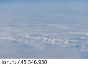 Aerial view of snow-capped mountains and clouds. Winter snowy mountain landscape. Kolyma Mountains on the border of Kamchatka Territory and Magadan Region, Far East Russia. Great background. Стоковое фото, фотограф Андрей Степанов / Фотобанк Лори