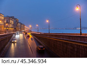 Beautiful evening view of the road on the embankment of the Neva River in the historic center of St. Petersburg. Cars are driving down the street. Traffic at dusk. Cold winter weather. Russia. Стоковое фото, фотограф Андрей Степанов / Фотобанк Лори