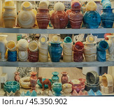 Handmade interior vases made of onyx,alabaster. Egyptian souvenirs on shelves of shop window. (2024 год). Редакционное фото, фотограф Ирина Кононова / Фотобанк Лори