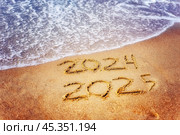 Новый 2025 год. Морская волна смывает с песчаного берега надпись "2024" Стоковое фото, фотограф Оксана / Фотобанк Лори