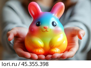 Яркая разноцветная игрушка в ладонях. Стоковое AI-изображение, AI-художник Щеголева Ольга / Фотобанк Лори