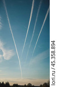 Chemtrail conspiracy theory. Long-lasting condensation trails left in sky by high-flying aircraft are actually chemtrails consisting of chemical or biological agents, sprayed for nefarious purposes. Стоковое AI-изображение, AI-художник Юлия Петровская / Фотобанк Лори