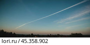 Chemtrail conspiracy theory. Long-lasting condensation trails left in sky by high-flying aircraft are actually chemtrails consisting of chemical or biological agents, sprayed for nefarious purposes. Стоковое AI-изображение, AI-художник Юлия Петровская / Фотобанк Лори