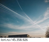 Chemtrail conspiracy theory. Long-lasting condensation trails left in sky by high-flying aircraft are actually chemtrails consisting of chemical or biological agents, sprayed for nefarious purposes. Стоковое AI-изображение, AI-художник Юлия Петровская / Фотобанк Лори