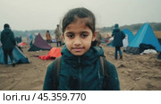 Young refugee girl standing in refugee camp. Стоковое видео, видеограф Данил Руденко / Фотобанк Лори