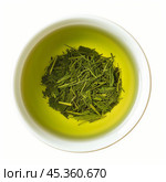 Green tea leaves steeping in a white bowl. Стоковое AI-изображение, AI-художник Иван Рябоконь / Фотобанк Лори