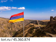 Aerial drone view to flag of Armenia and famous Vahramashen Church of the 11th century, near Amberd fortress in sunny summer day. Cliff with Arkashian River deep in canyon. Aragatsotn region, Armenia. Стоковое фото, фотограф Алексей Ширманов / Фотобанк Лори