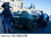 Люди с интересом смотрят на легкий танк времен ВОВ выставленный в музее военной техники под открытым небом на Красной площади в Москве в ноябре 2024 года. Редакционное фото, фотограф Елизавета Корнилова / Фотобанк Лори