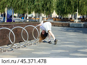 Молодая девушка балуется на стоянке электросамокатов. Стоковое фото, фотограф Роман Лукьянов / Фотобанк Лори