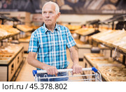 Elderly man buying bread and pastries in grocery section of the supermarket. Стоковое фото, фотограф Татьяна Яцевич / Фотобанк Лори