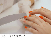 manicure worker smoothing customers nails with nail file. Стоковое фото, фотограф Сергей Толмачёв / Фотобанк Лори