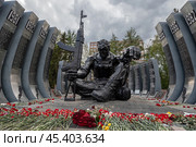 Чёрный тюльпан — мемориал уральским воинам-интернационалистам, погибшим в Афганистане, и воинам, погибшим в Чечне. Город Екатеринбург, Свердловская область, Россия. В центре композиции — фигура сидящего солдата с автоматом, вокруг которого установлены имитирующие каркас фюзеляжа военно-транспортного самолёта металлические пилоны с датами и списками погибших. Около памятника много цветов. (2023 год). Редакционное фото, фотограф Андрей Степанов / Фотобанк Лори