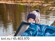 Мальчик в лодке. Его отец рядом ловит рыбу сетями, а он внимательно смотрит.. Их родовое имение находится в лесу ( недалеко от реки ). Они, коренные жители народов севера - ханты, здесь живут годами. Основные продукты - самые, что ни на есть натуральные. Все остальное покупают раз в месяц, в городе. Сообщение с городом круглый год по реке , километров 20-25... (2011 год). Редакционное фото, фотограф Павел Просянов / Фотобанк Лори