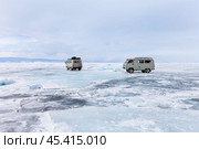 BAIKAL LAKE, OLKHON ISLAND, IRKUTSK REGION, RUSSIA - March 02, 2024: Tourists return from the famous Cape Khoboy in SUVs across snow-covered ice of Small Sea with cracks, faults and hummocks. Редакционное фото, фотограф Виктория Катьянова / Фотобанк Лори