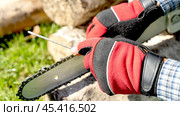 a master sharpens a chainsaw chain before work. Стоковое фото, фотограф Igor Skripachev / Фотобанк Лори