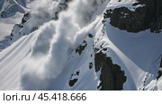 An avalanche thunders down a snow-covered mountain, a display of nature might. Mountainside snow collapse, a powerful force reshaping the landscape. Panorama with copy space. Стоковое AI-видео, аниматор Igor Tichonow / Фотобанк Лори