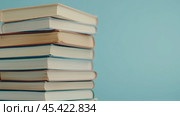 Стопка книг на синем фоне для образовательных и литературных тем. Стоковое AI-изображение, AI-художник ФотоИнтеллект / Фотобанк Лори