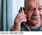 Разговор пенсионера с мошенниками. Fraud and deception. A shocked, worried elderly man in the process of talking to a scammer. Стоковое фото, фотограф Терехова Марина / Фотобанк Лори