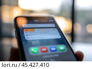 A person checks their smartphone, viewing notifications in the soft afternoon glow. Стоковое AI-изображение, AI-художник Елена Старчак / Фотобанк Лори