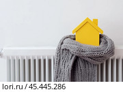 House model in a Scarf. Creativity Image of Cold Season. Heating System, Winter is Coming Creative Concept. Mini residential house Wearing a Knitted Warm Clothes. Electricity and Gas Price Rising. Стоковое AI-изображение, AI-художник Марина Демидюк / Фотобанк Лори