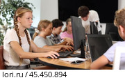 Concerned preteen girl working with computer programs with interest in training room. Стоковое видео, видеограф Яков Филимонов / Фотобанк Лори