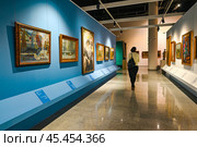Женщина осматривает картины в музейном комплексе им И.Я. Словцова. Город Тюмень (2023 год). Редакционное фото, фотограф Александр Тараканов / Фотобанк Лори