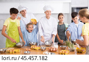 During childrens cooking class, little girl screams enthusiastically and raised two hands up. Стоковое фото, фотограф Яков Филимонов / Фотобанк Лори