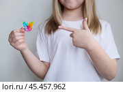 Детская зубная пластина радужного цвета. Ребенок держит в руках ортодонтическую пластинку, чтобы выровнять зубы и расширить челюсть. Стоковое фото, фотограф Терехова Марина / Фотобанк Лори