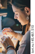 Jeweler working on necklace with illuminated magnifying glass. Стоковое AI-видео, аниматор Юрий Поздников / Фотобанк Лори