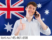 Young guy talking on phone in front of Australian flag. Стоковое фото, фотограф Татьяна Яцевич / Фотобанк Лори