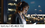 Businesswoman wearing headphones watching video webinar making conference online call writing notes talking, focused woman study online looking at laptop listening translating lecture course. Стоковое AI-изображение, AI-художник Sergey Grishin / Фотобанк Лори
