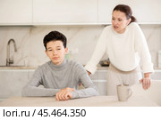 Portrait of offended boy sitting at home while mother berating him. Стоковое фото, фотограф Яков Филимонов / Фотобанк Лори