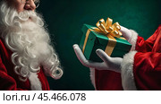 Hands of Santa Claus in close-up with a gift box in his hands on a green background. Gifts from Santa Claus. Стоковое AI-изображение, AI-художник Photojuli / Фотобанк Лори